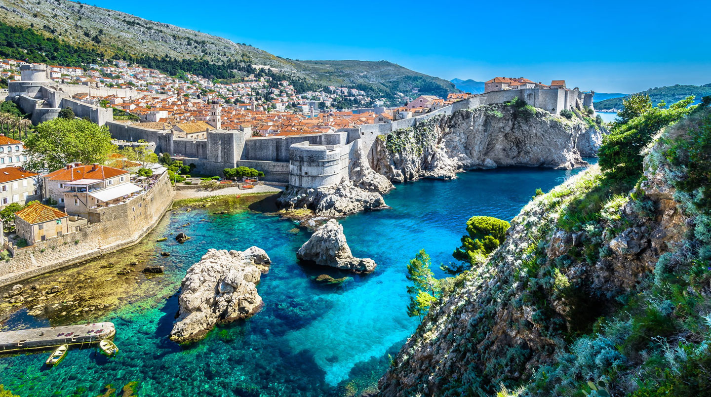 Luftaufnahme einer einsamen dalmatinischen Bucht in Kroatien mit türkisem kristallklarem Wasser und kleinem Holzboot